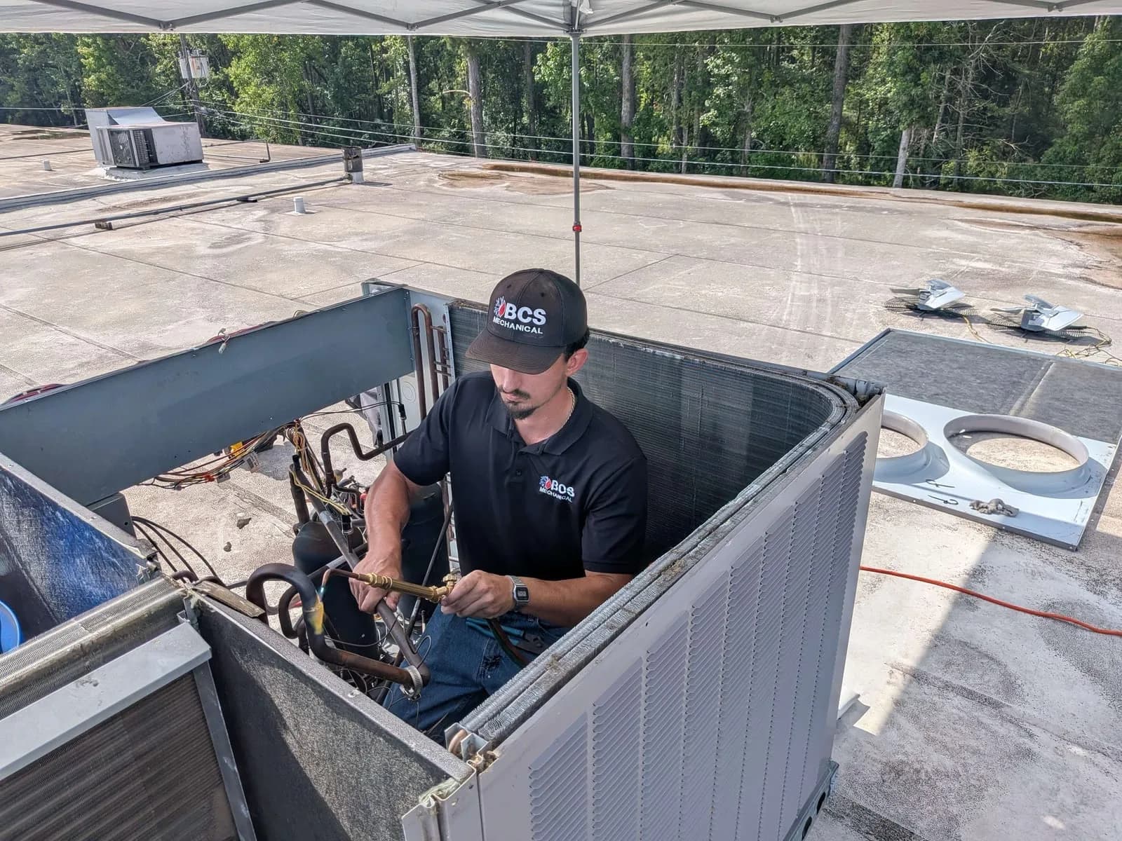 Technician servicing a rooftop package unit