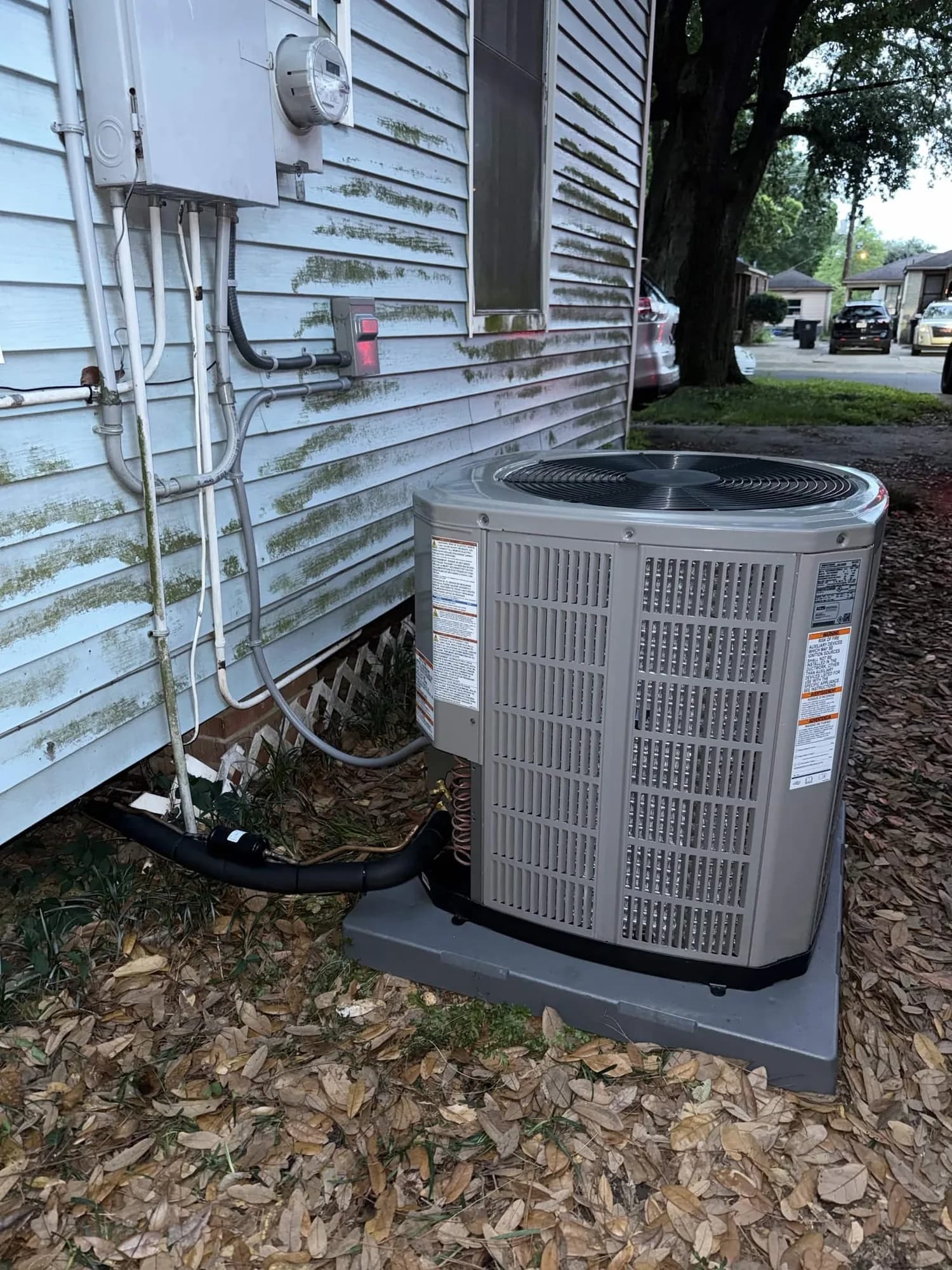New condenser installation beside a home